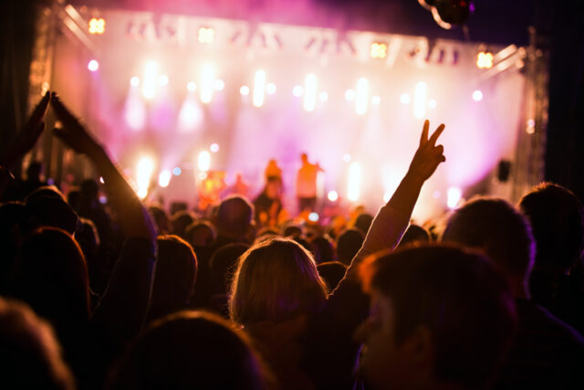 crowds of people having fun at an outdoor music concert with creative lighting